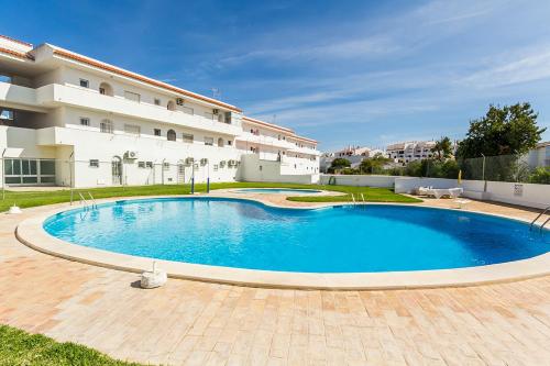 a large swimming pool in front of a building at Apartamentos Oura AreiaSol by Sunny Deluxe in Albufeira