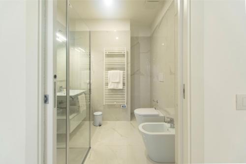 a white bathroom with a toilet and a sink at Residence Flow-R in Riccione
