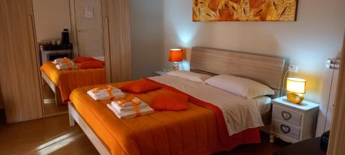 two beds in a room with orange and white at B&B LE BACETTE in Caprarola