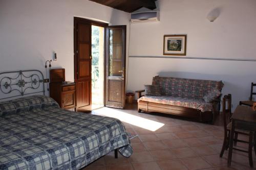 a bedroom with a bed and a couch at Azienda Agrituristica Le Puzelle in Santa Severina