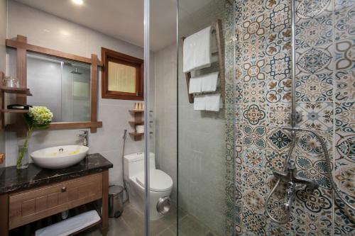 a bathroom with a toilet and a sink and a shower at Mai Chau Hideaway Lake Resort in Mai Châu