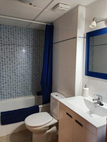 a bathroom with a white toilet and a sink at 1 bajo con 2 Terrazas piscina y jardin in Deltebre