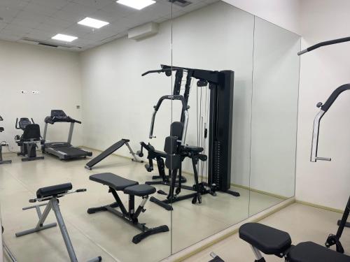 a gym with several tread machines and mirrors at Olympian Bay Grand Resort in Leptokarya