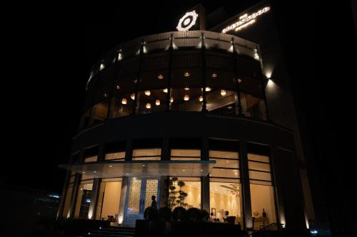 um edifício com um relógio em cima à noite em The Greenwood Guwahati - A Luxury Boutique Hotel em Guwahati