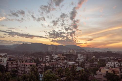 a view of a city at sunset at The Greenwood Guwahati - A Luxury Boutique Hotel in Guwahati