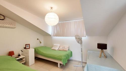 a small bedroom with a green bed and a window at Sunset Beach Vip 1 Residences in Konaklı