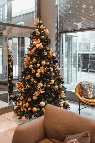 a christmas tree in a room with a couch at Radisson Collection Hotel, Warsaw in Warsaw