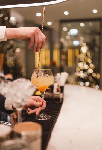 a person holding a drink in a wine glass at Radisson Collection Hotel, Warsaw in Warsaw