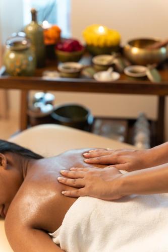 a woman laying on a massage bed with her legs at The Greenwood Guwahati - A Luxury Boutique Hotel in Guwahati