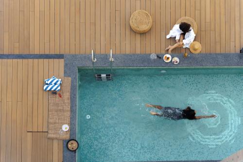 an overhead view of a man in a swimming pool at The Greenwood Guwahati - A Luxury Boutique Hotel in Guwahati