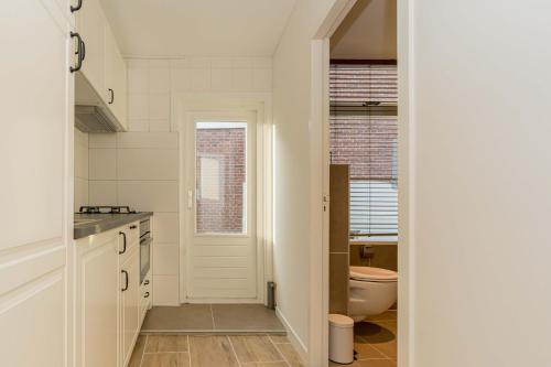 eine weiße Küche mit einem WC und einem Waschbecken in der Unterkunft Drie Wijzen in Zierikzee