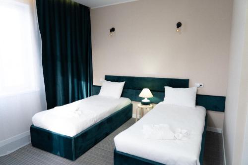 a hotel room with two beds and a window at Jardin in Aktobe