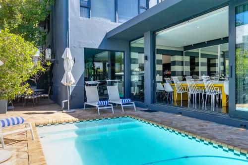 a swimming pool in front of a building with a restaurant at Life & Leisure Communal-Living in Stellenbosch