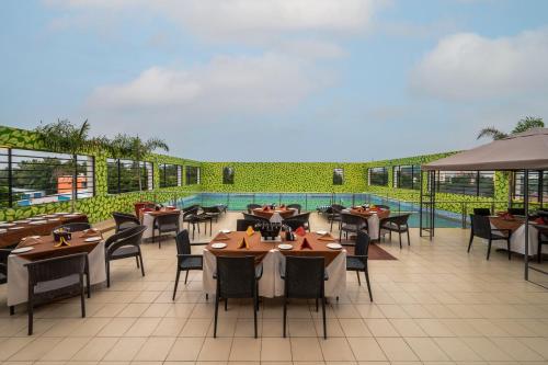 a restaurant with tables and chairs on a patio at Sterling V Grand Madurai in Madurai