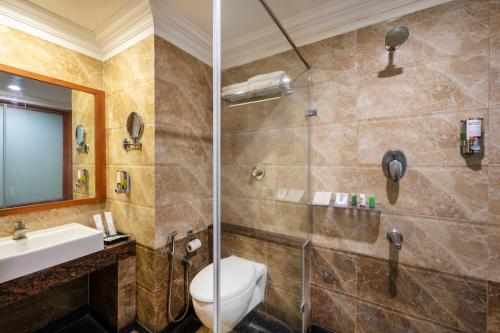 a bathroom with a toilet and a sink and a shower at Sterling V Grand Madurai in Madurai