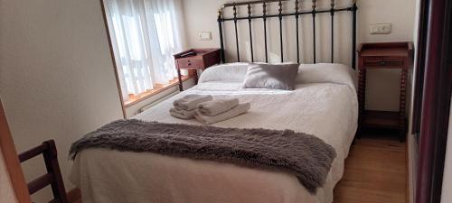1 dormitorio con 1 cama con toallas en Hotel valle de lago, en Valle de Lago