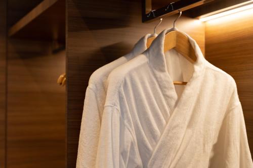 a rack of white shirts hanging on a door at The Greenwood Guwahati - A Luxury Boutique Hotel in Guwahati