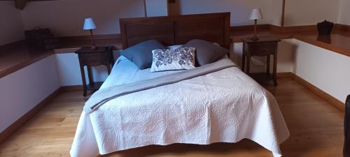 a bedroom with a bed with a white bedspread and two lamps at Hotel valle de lago in Valle de Lago