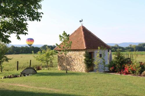 a small building in a field with a hot air balloon at Domaine du moulin de Jeanne in Courlaoux