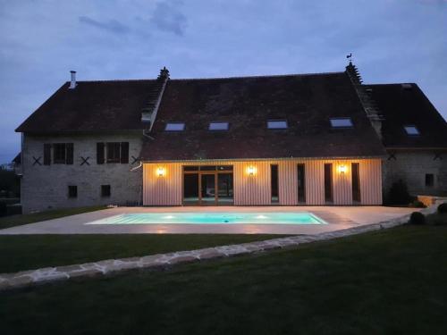 a house with a swimming pool in front of it at Domaine du moulin de Jeanne in Courlaoux