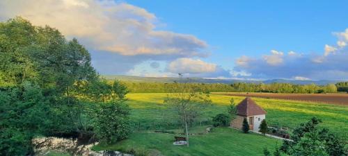 a field with a small building in the middle of it at Domaine du moulin de Jeanne in Courlaoux