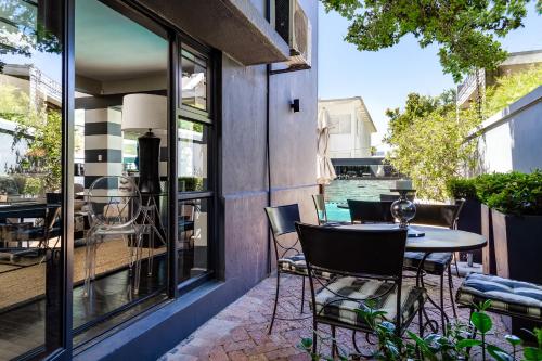 a patio with a table and chairs on a balcony at Life & Leisure Boutique Guesthouse in Stellenbosch