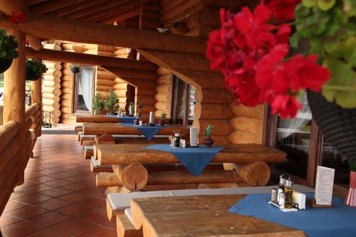 a row of tables on a porch of a log cabin at Székelyföld Fogadó in Borzont
