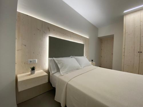 a bedroom with a large white bed with a headboard at IBSEN Almagro in Almagro