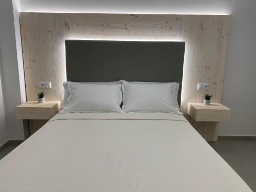 a large white bed with two night stands next to it at IBSEN Almagro in Almagro