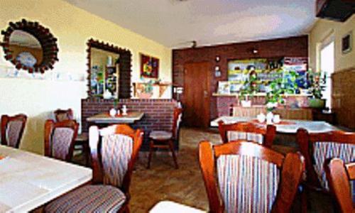 a dining room with tables and chairs in a restaurant at Pension Fröhlich in Gager