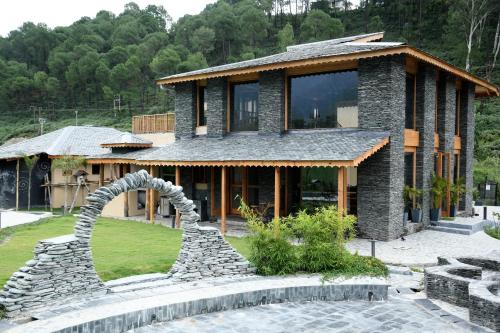 Osho Himalayas Wellness Resort في كانجرا: منزل به تمثال امام مبنى
