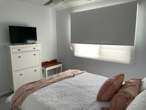 a bedroom with a bed and a television and a window at McCracken Homestay in McCracken