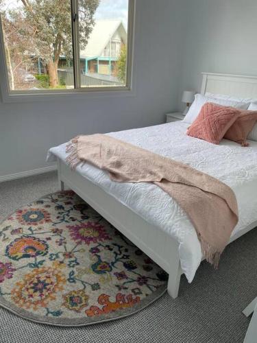 a bedroom with a bed with a rug and a window at McCracken Homestay in McCracken
