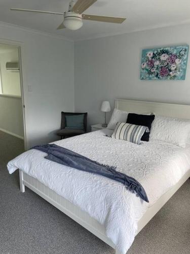 a bedroom with a large white bed with a ceiling at McCracken Homestay in McCracken