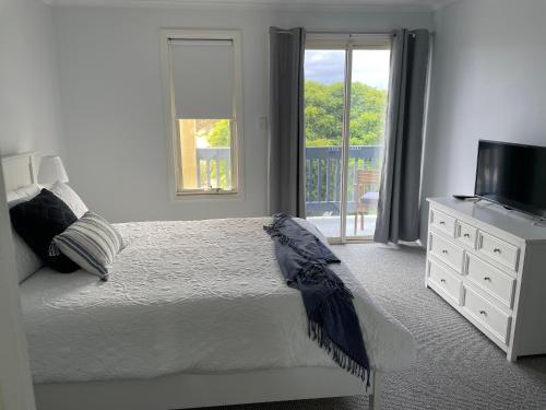 a bedroom with a bed and a television and a window at McCracken Homestay in McCracken