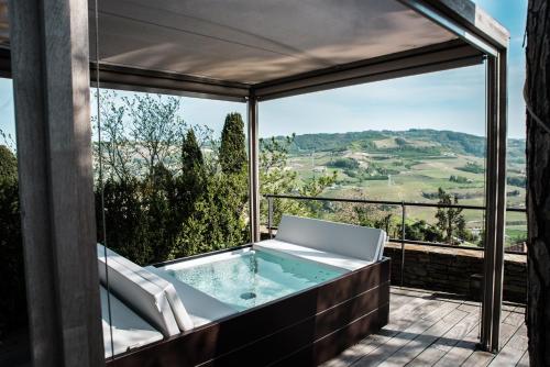 a jacuzzi tub on a balcony with a view at Relais San Maurizio in Santo Stefano Belbo