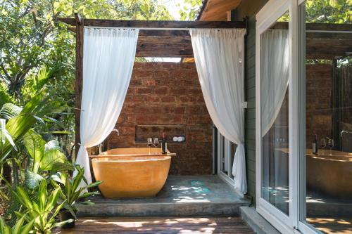a bathroom with two tubs on a patio at LaRiSa Resort & Spa, Ashwem in Mandrem