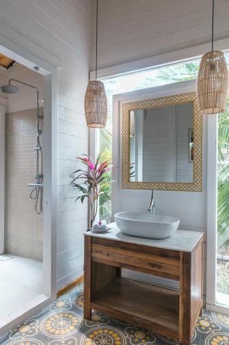 a bathroom with a sink and a mirror at LaRiSa Resort & Spa, Ashwem in Mandrem