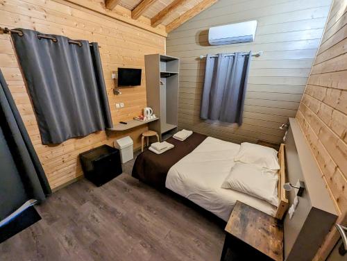 - une chambre avec un lit, un bureau et un miroir dans l'établissement Lodge Hôtel & Spa Les Voiles du Grand Large, à Meyzieu