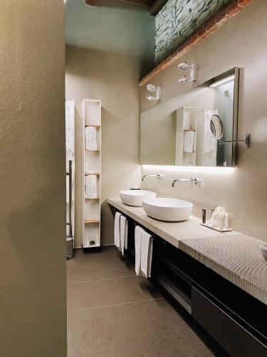 a bathroom with two sinks and a large mirror at Relais San Maurizio in Santo Stefano Belbo