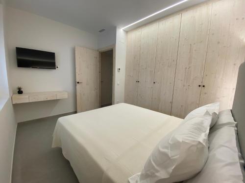 a bedroom with a white bed and a tv at IBSEN Almagro in Almagro
