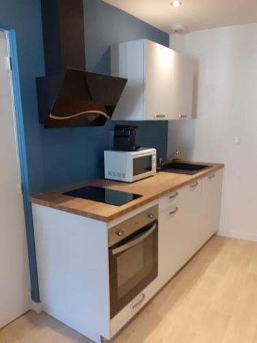 une cuisine avec un micro-ondes et une cuisinière four supérieur dans l'établissement Appartement rénové dans le centre historique, à Cahors