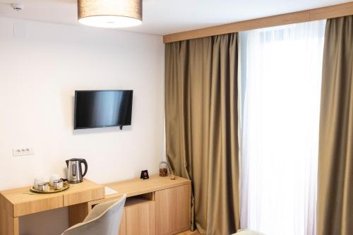 a hotel room with a tv and a window at Prenoćište restoran Bukulja in Arandjelovac