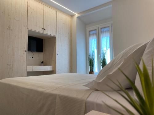a white bedroom with a bed and a tv at IBSEN Almagro in Almagro