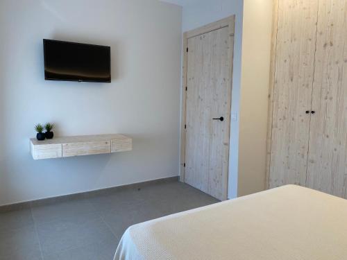 a bedroom with a bed and a tv on a wall at IBSEN Almagro in Almagro