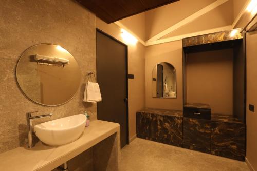 a bathroom with a sink and a mirror at Isola Luxury Farm Suites in Nashik