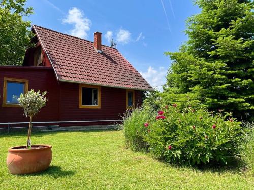 a red house with a plant in a yard at Kisház in Gárdony