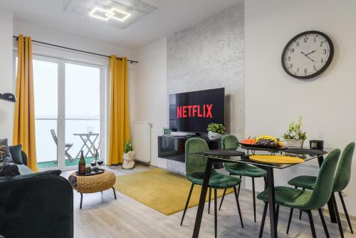 a living room with a table and a clock on the wall at Modern apartments on Adama Mickiewicza street in Łódź