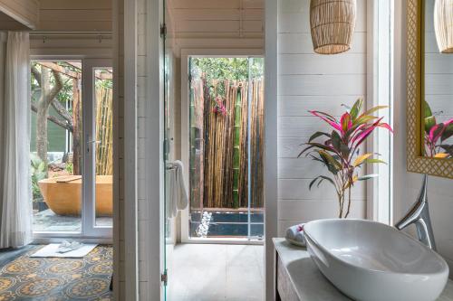 a bathroom with a tub and a sink in a room at Larisa Resort Ashwem in Mandrem