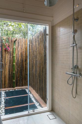 a shower with a glass door in a bathroom at LaRiSa Resort & Spa, Ashwem in Mandrem